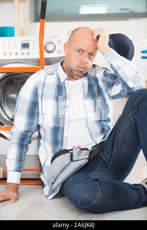 exhausted man having a hard time at work Stock Photo