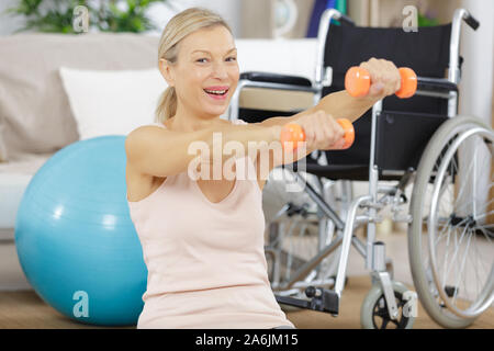cheerful senior lady exercising with dumbbells in the home Stock Photo