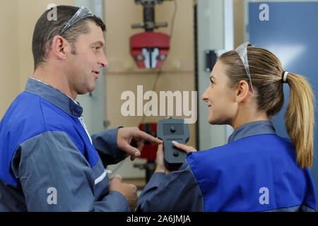 female worker training to use remote controls for machinery Stock Photo