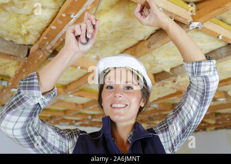 happy electrician installing ceiling lights in domestic home Stock Photo