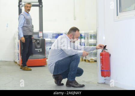 professional checking a fire extinguisher Stock Photo