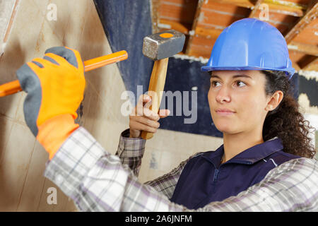 a female worker is using a hammer Stock Photo