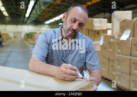 delivery man hold box in warehouse Stock Photo