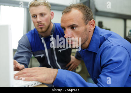 experienced auto mechanic using a laptop Stock Photo