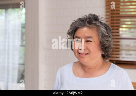 Asian senior woman smile in living room at home,Happy aging at home concept Stock Photo