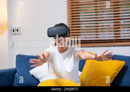 Young asian  woman touching air during the VR reality experience wearing virtual reality goggles .future technology concept Stock Photo