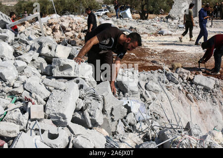 Barisha, Syria. 27th Oct, 2019. Syrians inspect the debris of a house following an alleged US-led raid at the northwestern Syrian village of Barisha in the province of Idlib near the border with Turkey, after media reports said Islamic State (IS) leader Abu Bakr al-Baghdadi was believed to be killed in a US Special Forces raid on the outskirts of Barisha. Credit: Mustafa Dahnon/dpa/Alamy Live News Stock Photo