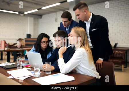 young people in elegant suits working with laptop in the mordern room, studends preparing for exam, making presentation. close up side view photo. Stock Photo