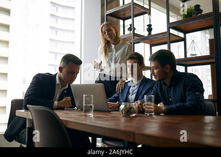 young men and woman developing a plan of startup business. close up photo. paanorama window in the background of the photo Stock Photo