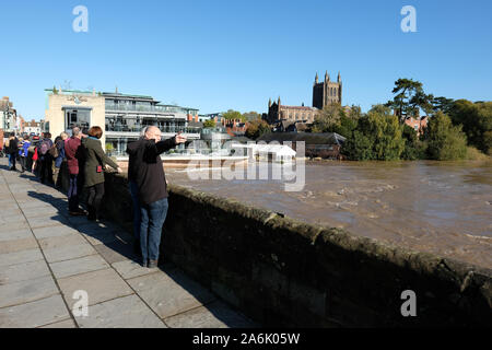Hereford, Herefordshire, UK - Sunday 27th October 2019 - The River Wye is at an extremely high level after recent heavy rainfall - visitors stop on the old Wye Bridge to view the high river level and the large amount of debris blocking several bridge arch spans. Photo Steven May / Alamy Live News Stock Photo