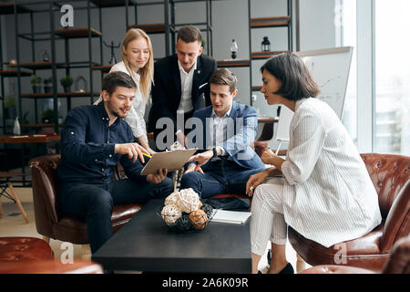 young handsome man and his team studing project in the office room. close up photo, consultation concept Stock Photo