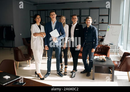 Portrait of successful group of business people standing in the modern office room. full length photo.leader of company and his team posing to the cam Stock Photo