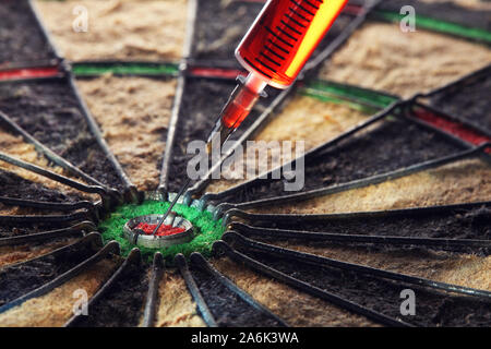 Syringe is stuck in the center of a dart board. Concept of accuracy in disease diagnosis and treatment. Stock Photo