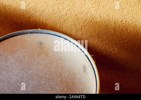 Close up overhead detail of a snare drum aligned to a yellow wall with copy space Stock Photo