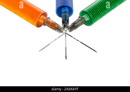 Three syringes filled with colorful liquids against isolated white background Stock Photo