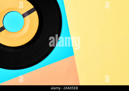 Vinyl record on pastel blue yellow and pink background. Overhead view with geometric shapes with copy space. Stock Photo