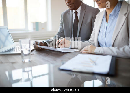 Cropped image of unrecognizable business people signing contract during meeting in office, focus on female hand holding pen, copy space Stock Photo