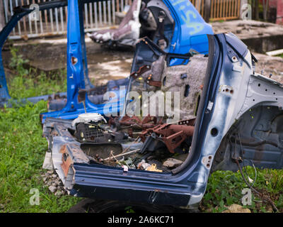 Old rusty half cut car by the road side after the accident at the workshop Stock Photo