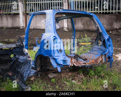 Old rusty half cut car by the road side after the accident at the workshop Stock Photo