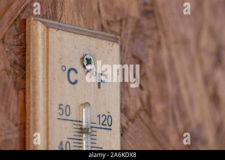 Heat temperature thermometer on the wooden wall outside the house Stock Photo