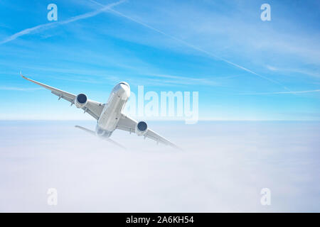 Passenger airplane gains altitude flying through a dense cloud layer Stock Photo