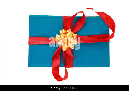Gift book wrapped in red ribbon with a bow on a white background. Stock Photo