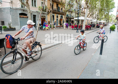 Barcelona Spain,Catalonia El Poblenou,Rambla del Poblenou,pedestrian promenade,man,boy,girl,father,son,family,riding bicycles,helmet,children,ES190820