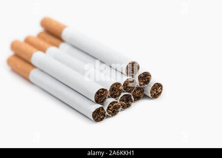 Pile of ten cigarettes on white background. The risk of illness is significantly reduced if you smoke less than 10 cigarettes per day Stock Photo