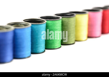 Rainbow arranged colorful bobbin thread hobby needlework on a white background. Stock Photo