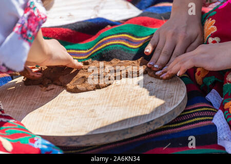 Women making bulgarian traditional pan for baking bread called podnik or podnitsa Stock Photo