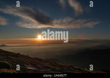 Sunset behind the clouds. Late evening. The setting sun. Stock Photo