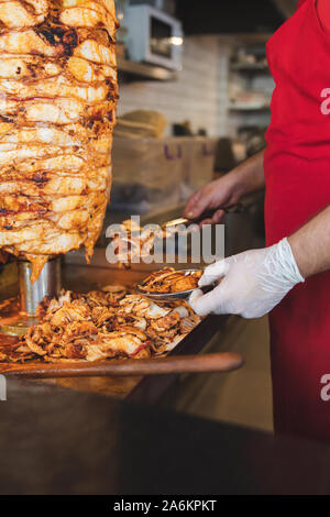 Chef preparing and making Traditional Turkish Doner Kebab meat. Shawarma or gyros. Turkish, greek or middle eastern arab style chicken doner kebab. Stock Photo