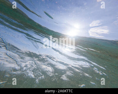 Underwater view of waives crashing. Beautiful sunlight coming through the water surface. Stock Photo