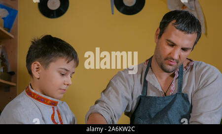 Potter showing how to work with ceramic in pottery studio Stock Photo