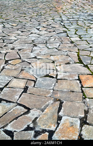 Stone pavement in perspective. Granite cobblestoned pavement background. Abstract background of a cobblestone pavement close-up. Stock Photo