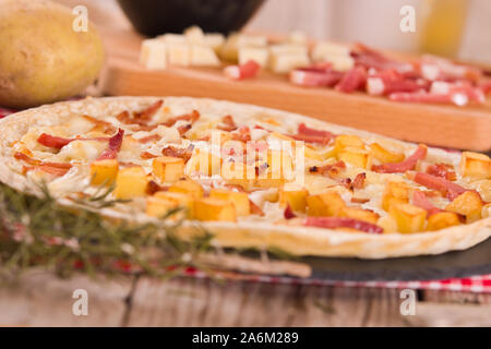 Tart with fried potato, raclette cheese and smoke flavour bacon. Stock Photo