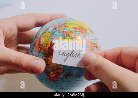 Hand holding notepaper with English wording on model globe Stock Photo