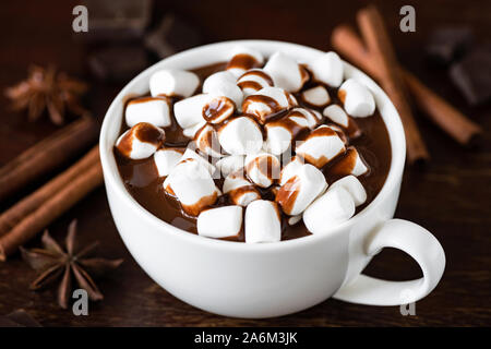 Hot chocolate with chocolate sauce and marshmallows in white cup. Closeup view Stock Photo