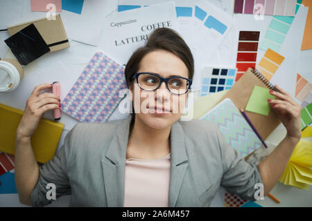 Above view portrait of stressed young businesswoman lying on floor surrounded by work supplies, copy space Stock Photo