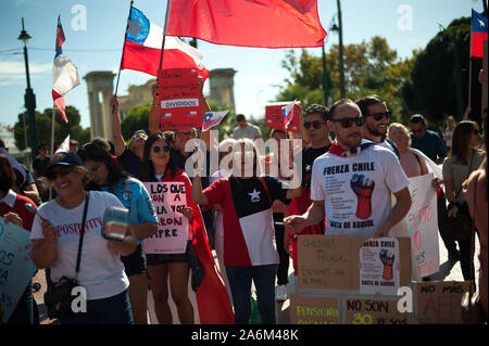 Protesters hold Chileans flags and placards during the demonstration.Chileans protest in support of their compatriots and against the economic measures by government of Sebastian Pinera. Stock Photo