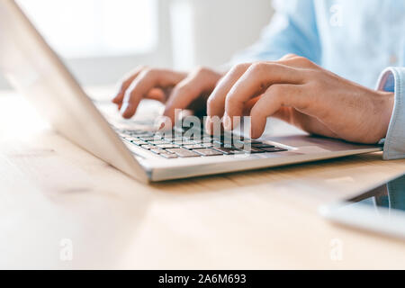 Hands of young businessman or analyst pressing keys of laptop keypad Stock Photo