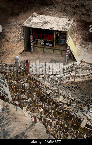 Heart-shaped padlocks set by lovers as a promise of eternal love, and the shop where they can be bought, Overhanging Great Wall, China Stock Photo