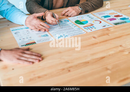 Hands of contemporary analysts or economists analyzing financial data on papers Stock Photo