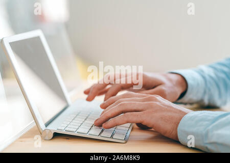 Hands of designer touching keys of keypad while working in front of touchpad Stock Photo