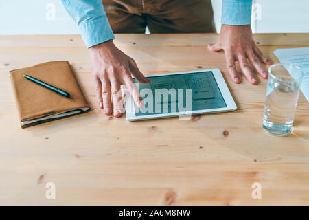 Hands of young website designer over program design on display of touchpad Stock Photo