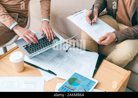 Programmers or designers of software working with online data and papers Stock Photo
