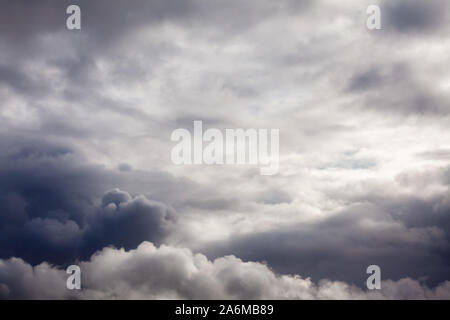 Grey stormy clouds with light peeking through. Skyline cloudscape with rain clouds Stock Photo