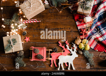 Toy deer and sledge, giftboxes, pine cones, conifer, garlands and decorations Stock Photo