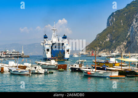 ISLE OF CAPRI, ITALY - AUGUST 2019: Large car and passenger ferry departing harbour on the Isle of Capri. Stock Photo