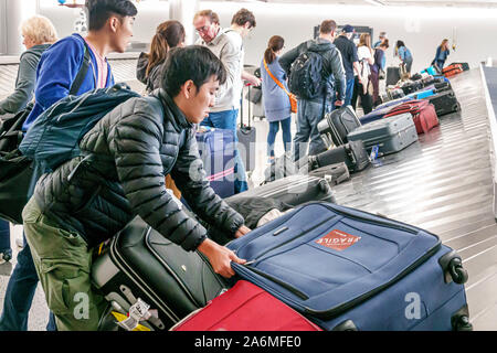Georgia,Atlanta,Hartsfield-Jackson Atlanta International Airport,inside interior,flight arrival,baggage claim,carousel,luggage,Asian Asians ethnic imm Stock Photo